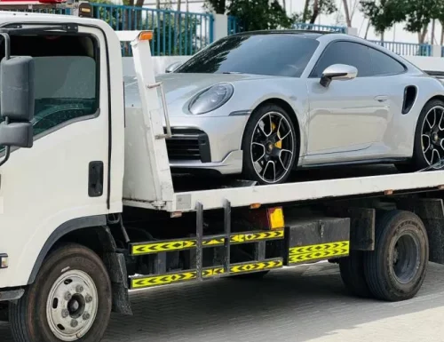 Silver sports car on flatbed tow truck